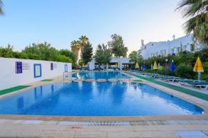una gran piscina con sillas y un edificio en Hotel Baba, en Gümbet