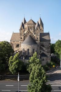 un grand bâtiment en pierre avec une rue devant lui dans l'établissement Über den Dächern von Koblenz, à Coblence