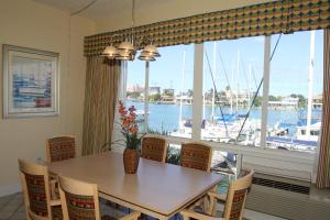 a dining room table with chairs and a window at Chart House Suites on Clearwater Bay in Clearwater Beach