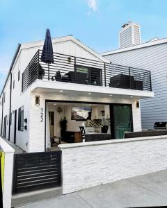 a white house with a balcony and an umbrella at 3 Bedrooms in Newport Beach