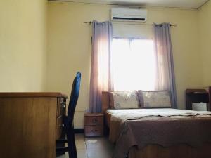a bedroom with a bed and a window at Single Room - Ground Floor in Accra