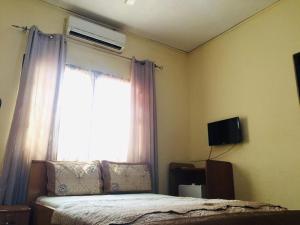 a bedroom with a bed and a window at Single Room - Ground Floor in Accra