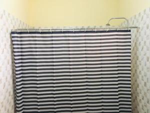 a bathroom with a blue and white shower curtain at Single Room - Ground Floor in Accra