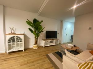 a living room with a couch and a tv at El Paraíso de Fuentebravía - Primera Línea de Playa in El Puerto de Santa María