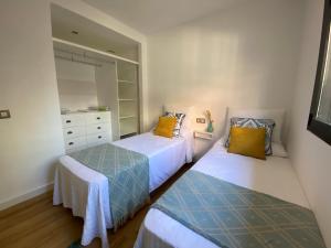 a bedroom with two beds and a dresser at El Paraíso de Fuentebravía - Primera Línea de Playa in El Puerto de Santa María