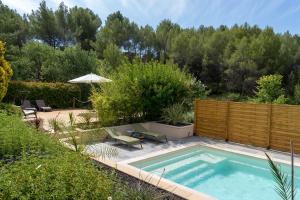 a small swimming pool in a garden with a wooden fence at Juste en Provence in Saint-Saturnin-les-Apt