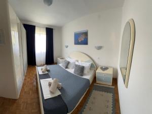 a small bedroom with a bed and a mirror at Apartments Oxygen in Račišće