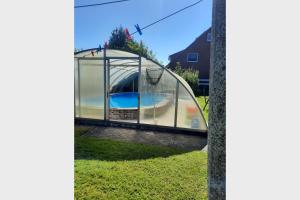 a glass house with a swimming pool inside at Nord-Strand in Norden