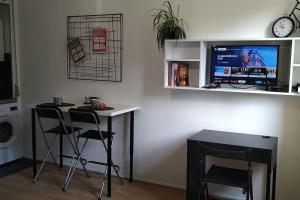 une pièce avec une table et deux chaises et une télévision dans l'établissement Nice studio near Disneyland and Paris with Parking, à Bussy-Saint-Georges