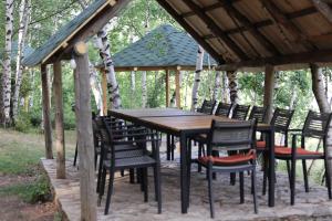 a wooden table and chairs under a gazebo at Stani i Hoxhes Hotel in Kukës