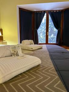 a bedroom with two beds and a large window at Posada del Ciprés in Villa La Angostura