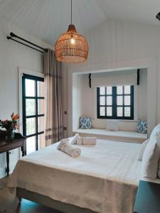 a bedroom with a large white bed with a large window at Viento Villa in Cesme +21 photos
