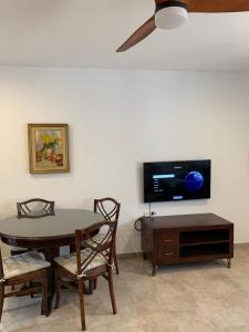 a dining room with a table and a tv at LA BARRACA - A - Relax, Terraza cerca del mar in Mojácar