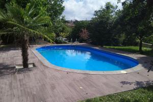 a large blue swimming pool with a wooden deck at Sweet Home Braga - 4 rooms apartment in Braga