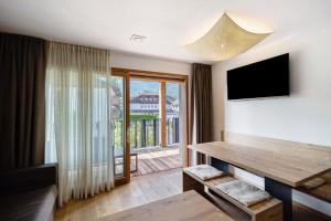 a living room with a television and a table at Villa Kriendl Nr 3 Piz da Peres in Valdaora