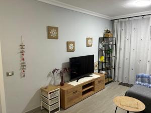 a living room with a television on a wooden entertainment center at Residencial Atlantico I in Costa Del Silencio