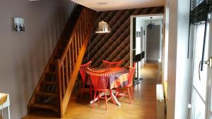 a dining room with a table and red chairs at Le Duplex in Honfleur