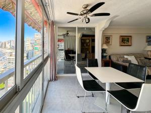 una sala de estar con una mesa y sillas en Carabelas 3, en Benidorm 3 fotos más