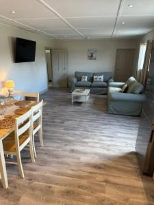 a living room with a couch and a table at The Jockey's Lodge @ Danebury in Stockbridge +15 photos