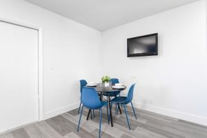a dining room with a table and blue chairs at Amazing unit with pool & parking at the beach - M35 in Hollywood