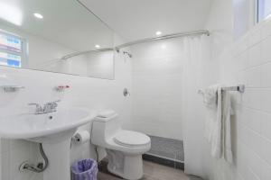 a white bathroom with a sink and a toilet at Amazing unit with pool & parking at the beach - M35 in Hollywood +8 photos
