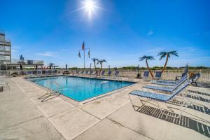 ein Swimmingpool mit blauen Stühlen und Palmen in der Unterkunft Sun-Soaked Wildwood Getaway, 6 Mi to Cape May! in Wildwood Crest