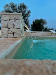 a water fountain in a swimming pool at Trullo Tatauan in San Michele Salentino