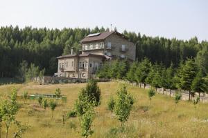 an old house on a hill in a field at Stani i Hoxhes Hotel in Kukës