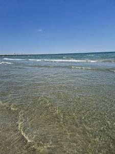 a beach with the ocean and some waves at Seb apartment mamaia nord in Năvodari +16 photos