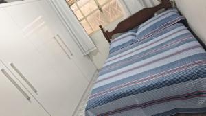 a bed in a small room with a window at Casa de Temporada em Diamantina in Diamantina