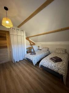 ein Schlafzimmer mit zwei Betten und einem Kronleuchter in der Unterkunft Gîte 5 personnes in Le Bonhomme