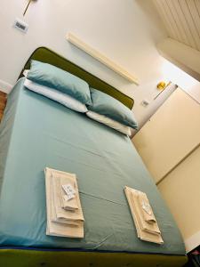 a bed in a room with green sheets and pillows at ROOMS AND BREAKFAST LABERINTO in San Benedetto del Tronto