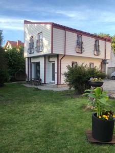 a house with a yard with a plant in front of it at Vila Venecija in Palanga