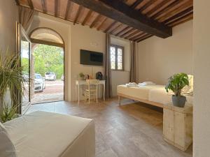 科莱萨尔韦蒂Agriturismo Tenuta i 4 venti的带床和桌子的卧室
