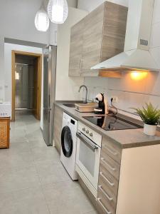 a kitchen with a stove and a washing machine at uim mediterraneio PB vicente andres estelles wifi in Puerto de Sagunto