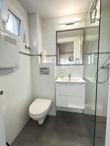 a white bathroom with a toilet and a sink at BiesCzadowa Dolina in Ustrzyki Dolne