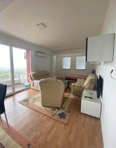 a living room with couches and a flat screen tv at Skopje City View Condominium in Skopje