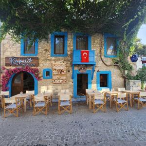 a group of tables and chairs in front of a building at Kapela Taş Otel Alaçatı in Çeşme