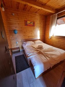 a bedroom with a bed in a wooden cabin at Pensiunea Azurul in Sovata