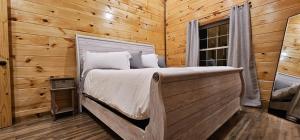 a bedroom with a bed in a log cabin at HotTub, Arcade - Less than 15 min to all RRG Attractions in Rogers
