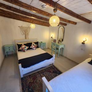 a bedroom with a white bed and a table at Kapela Taş Otel Alaçatı in Çeşme