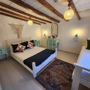 a bedroom with a large bed and a rug at Kapela Taş Otel Alaçatı in Çeşme +16 photos