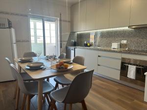 cocina con mesa de madera con sillas y comedor en Casa Janivo, en Armação de Pêra