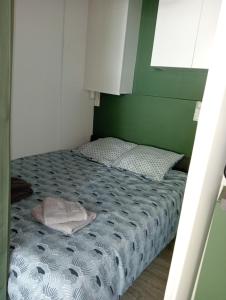 un letto in una stanza con una parete verde di Petit nid d’amour a Cap d'Agde