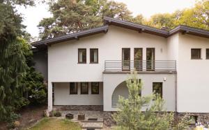 ein weißes Haus mit einem schwarzen Dach in der Unterkunft Chill&SPA Villa 30 min od Warszawy, Jacuzzi, Sauna, Sport in Konstancin-Jeziorna