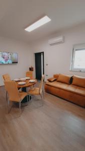 a living room with a couch and a table and chairs at Apartments ROKO in Izola +37 photos