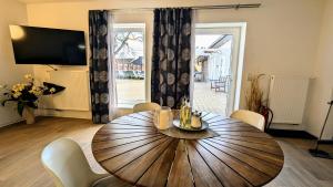 a dining room with a wooden table and chairs at FeWo Urban Gotha - Apartment Orangerie - Am Schlosspark- Parken an der der Tür- Barrierefrei, 900 Meter zum Bahnhof - Wallbox in Gotha