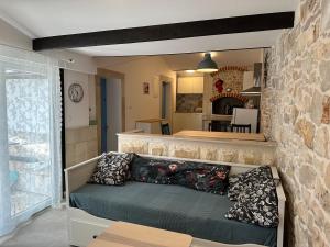 een woonkamer met een bank en een stenen muur bij Apartment By the Sea in Milna