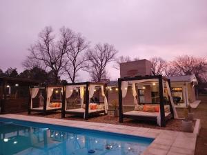 a group of beds in a room next to a pool at FRAMA Cabañas del Lago in Potrero de Garay +18 photos