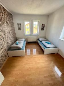 two beds in a room with two windows at Promotion Prices Monteurwohnung nahe Pforzheim und Karlsruhe in Birkenfeld